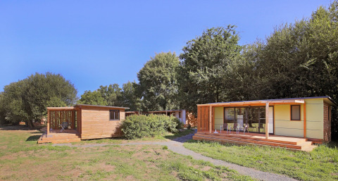 Mobile home Vancouver: billeder af moderne træhytter med terrasser i en grøn, fredelig skovomgivelse.