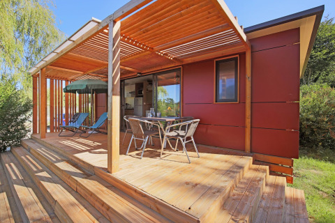 Mobile home Vancouver en Huttopia Baie du Mont St Michel, Francia, con terraza de madera y muebles.