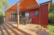 Mobile home Vancouver en Huttopia Baie du Mont St Michel, Francia, con terraza de madera y muebles.