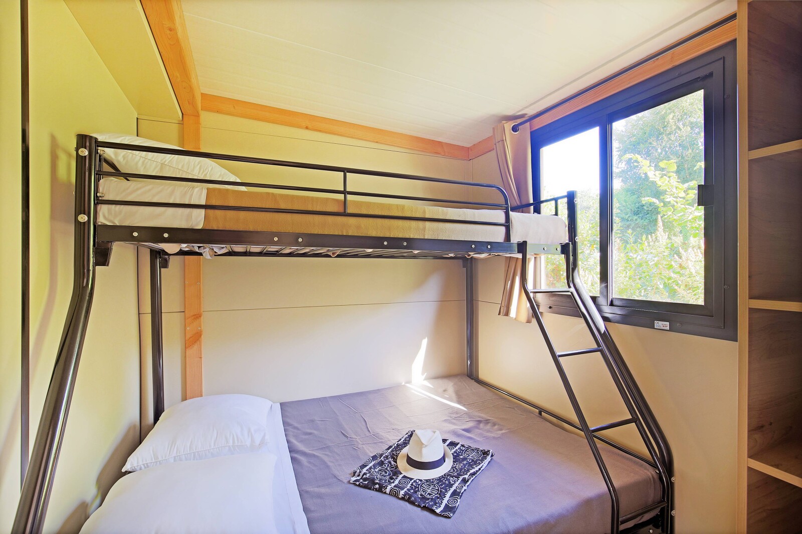 Interieur van cabine met stapelbed en groot raam, Mobile home Vancouver, Huttopia Baie du Mont St Michel, Frankrijk.