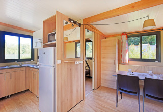 Vista interior de la mobile home Vancouver en Huttopia Baie du Mont St Michel, con cocina y zona de comedor.