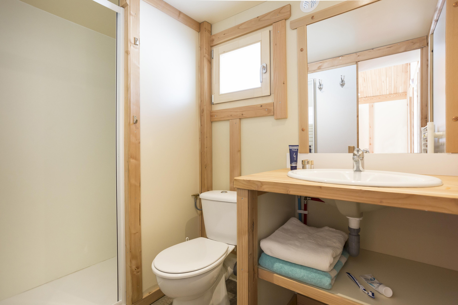 Lichte badkamer met houten accenten in Chalet Montana bij Huttopia Bozel en Vanoise, Frankrijk.