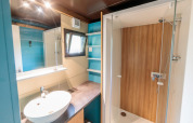 Moderne badkamer in Chalet Evasion bij Huttopia Landes Sud, Frankrijk, met een douche en wastafel.