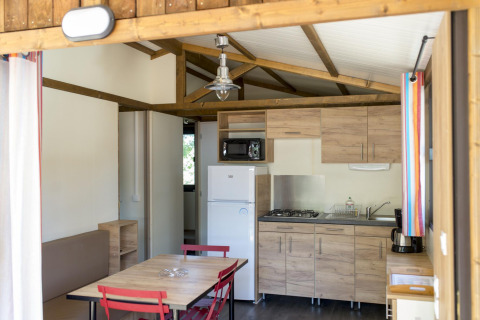 Cocina moderna y comedor dentro de un Chalet Evasion en Huttopia le Moulin, Francia.