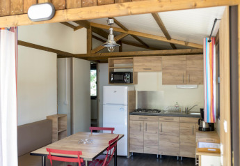 Modern eingerichtete Küche und Essbereich in einer Chalet Evasion-Hütte bei Huttopia le Moulin, Frankreich.