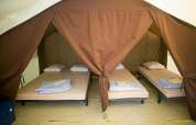 Interieur van een Bungalow tent Classic bij Huttopia Oléron les Pins in Frankrijk met opgemaakte bedden.