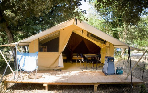 Tenda safari Toile&bois Classic con veranda in legno nella natura, campeggio Huttopia Noirmoutier in Francia.