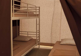 Interieur van een safaritent met stapelbed en enkel bed in Toile&Bois Classic bij Huttopia Oléron les Pins in Frankrijk.