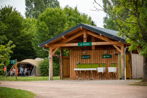 Edificio sanitario al aire libre con fregaderos y lavandería en Huttopia Etang de Fouché, Bourgogne-Franche-Comté.