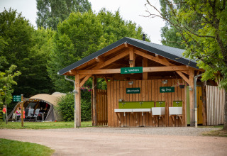 Udendørs sanitetsbygning med opvask og vaskestationer på Huttopia Etang de Fouché i Bourgogne-Franche-Comté.