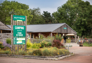 Indgang til Huttopia Etang de Fouché campingplads i Bourgogne-Franche-Comté, Frankrig, omgivet af natur.
