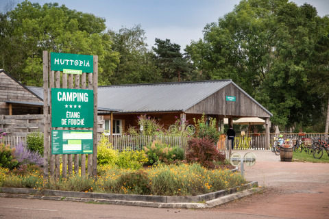 Entrada y recepción del camping Huttopia Etang de Fouché en Bourgogne-Franche-Comté, Francia, rodeado de naturaleza.