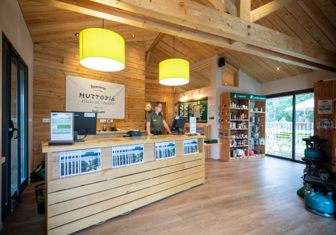 Recepción con decoración de madera en Huttopia Etang de Fouché, parque de vacaciones en Bourgogne-Franche-Comté, Francia.