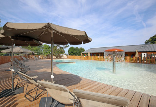 Schwimmbad mit Sonnenliegen und Sonnenschirmen im Ferienpark Huttopia Etang de Fouché, Bourgogne, Frankreich.