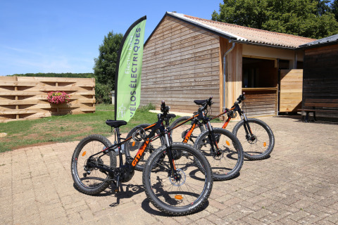 Bicicletas eléctricas de alquiler frente a una cabaña en el parque vacacional Huttopia Etang de Fouché en Borgoña, Francia.
