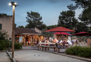 Buitenzitruimte bij Huttopia Fontvieille vakantiepark in Provence-Alpes-Côte d’Azur, Frankrijk met bezoekers.
