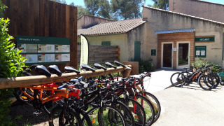 Bicicletas de alquiler junto al edificio de recepción en Huttopia Fontvieille, un parque vacacional en Provenza.