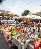 Mercado al aire libre cerca de Fontvieille, Provenza, con cerámica y cestas coloridas en los puestos.