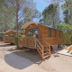 Cabañas de madera en un bosque, Roulotte en Huttopia Fontvieille Francia, con porche y mesa de picnic.