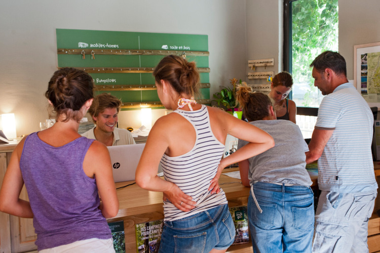 Des vacanciers s'enregistrent à la réception du parc Huttopia Gorges du Verdon en Hauts-de-France, France.