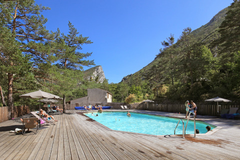Piscina al aire libre con terraza de madera en Huttopia Gorges du Verdon, parque vacacional en Hauts-de-France.