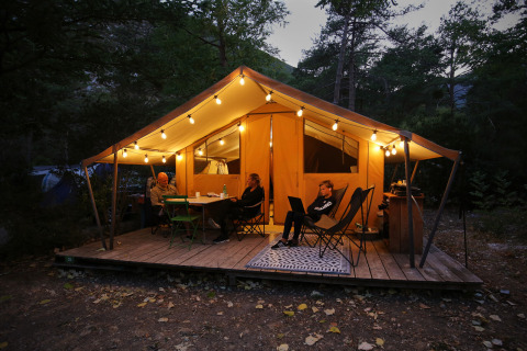 Tienda safari Bungalow tent Classic en Huttopia Gorges du Verdon, Francia, iluminada al atardecer.