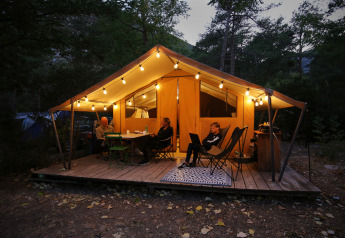 Evening at a safari Bungalow tent Classic at Huttopia Gorges du Verdon in France, warmly lit and cozy.