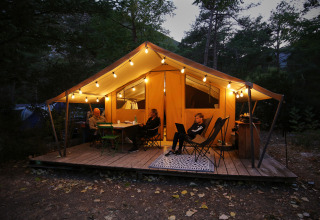Tenda safari Bungalow Classic di Huttopia Gorges du Verdon in Francia illuminata di sera.