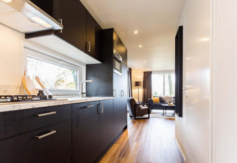 Cucina moderna e soggiorno nel lodge Module Wood Hottub al Bospark Ede, Paesi Bassi, arredo elegante.