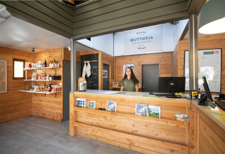 Receptionen på Huttopia Lac de Carcans-ferieparken i Nouvelle-Aquitaine, Frankrig, med venligt personale.