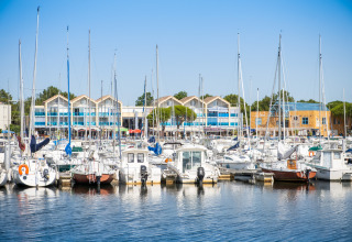 View of boats docked at the marina in Huttopia Lac de Carcans holiday park, Nouvelle-Aquitaine, France, on a sunny day.