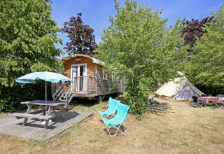Campingplads ved Huttopia Etang de Fouché med træhytte, telt, picnicbord og stole i Bourgogne, Frankrig.