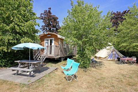 Kampeerplek bij Huttopia Etang de Fouché met hut, tent, picknicktafel en stoelen in Bourgogne, Frankrijk.