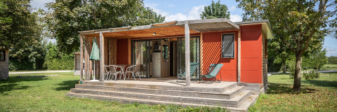 Casa móvil Vancouver en Huttopia Etang de Fouché, Francia, con terraza de madera y muebles de exterior rodeada de verde.