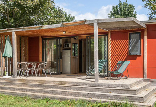 Mobilheim Vancouver bei Huttopia Etang de Fouché in Frankreich mit Veranda und Gartenmöbeln in der Natur.