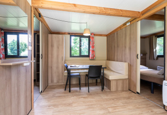 Modernes, helles Interieur des Mobile home Vancouver mit Essbereich, Fenstern und sichtbarem Schlafzimmer.