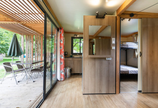 Vista interior de Mobile home Vancouver, mostrando la terraza, comedor y dormitorio con literas.