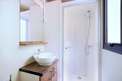 Bagno moderno con cabina doccia, specchio, lavabo e finestra nella casa mobile Vancouver.