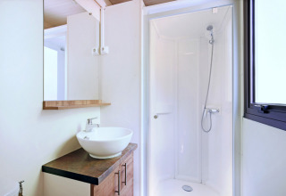 Moderne badkamer met douche, spiegel, waskom en raam in Mobile home Vancouver chalet.