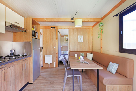 Modern interieur van Chalet Ottawa aan Huttopia Etang de Fouché in Frankrijk, met keuken en eettafel.