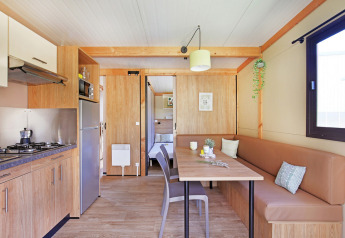 Moderne interiør af Chalet Ottawa ved Huttopia Etang de Fouché i Frankrig med køkken og spiseområde.