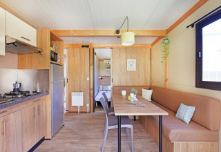 Modernes Interieur des Chalet Ottawa bei Huttopia Etang de Fouché in Frankreich mit Küche und Essbereich.