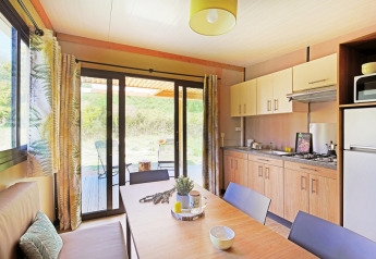 Cocina y comedor luminosos en el Chalet Ottawa de Huttopia Etang de Fouché en Francia con vista al jardín.