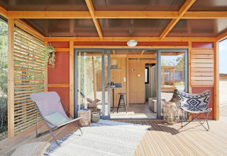 Outdoor patio of Chalet Victoria at Huttopia Gorges du Verdon, France, featuring modern chairs and wood décor.