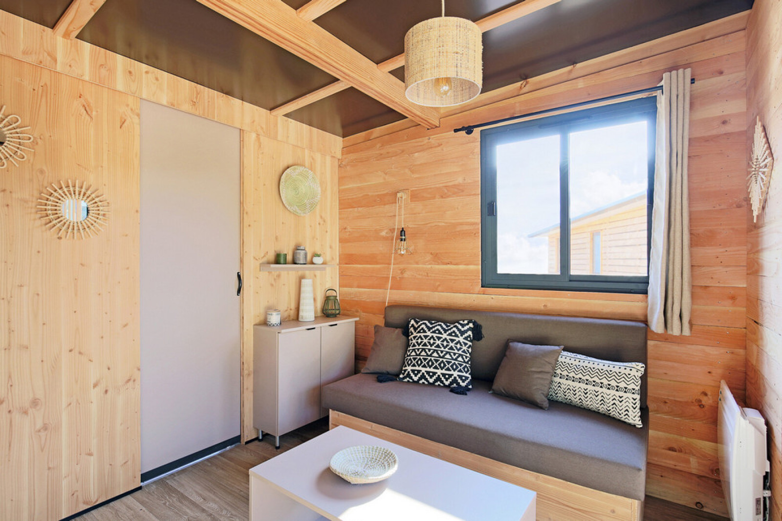 Knusse woonkamer in Chalet Victoria bij Huttopia Gorges du Verdon, Frankrijk, met houten interieur.