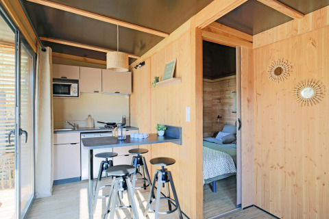 Interieur van Chalet Victoria bij Huttopia Gorges du Verdon, Frankrijk, met houten wanden en moderne keuken.