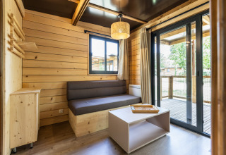 Interior de madera clara del Chalet Victoria en Huttopia Gorges du Verdon, Francia, con terraza y decoración moderna.