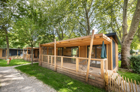 Cabañas de madera en Camping de Paris, rodeadas de árboles en Île de France, Francia.
