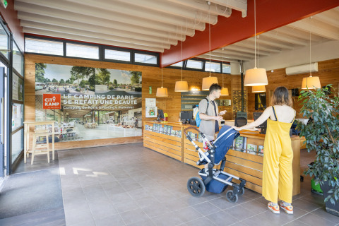 Réception du Camping de Paris en Île de France avec des clients arrivant dans un espace rénové.