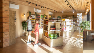Escena de compras en la tienda de Camping de Paris, con dos personas y estantes iluminados.
